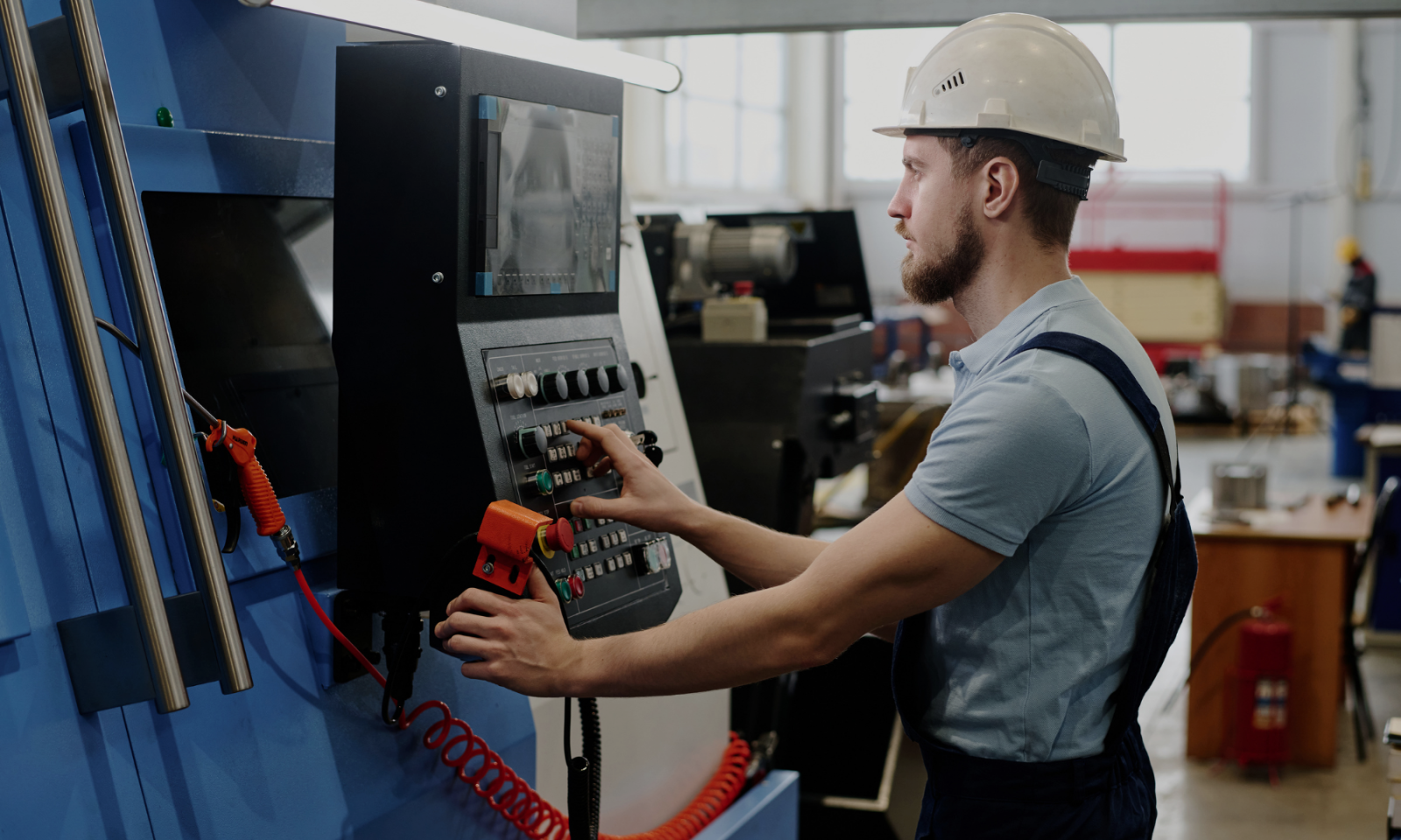 CNC machine operator working at a CNC machine control panel