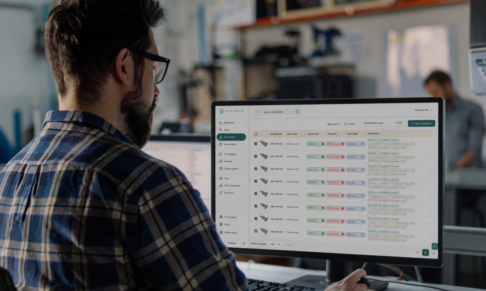 Programmer using Toolhive software to view and manage tool assemblies on a desktop monitor.