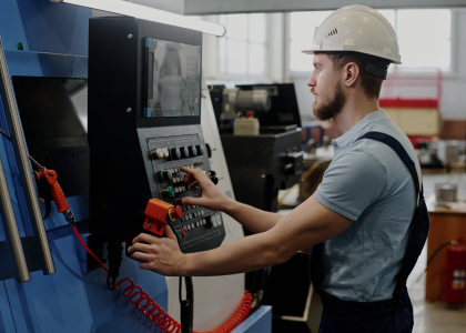 CNC machine operator working at a CNC machine control panel