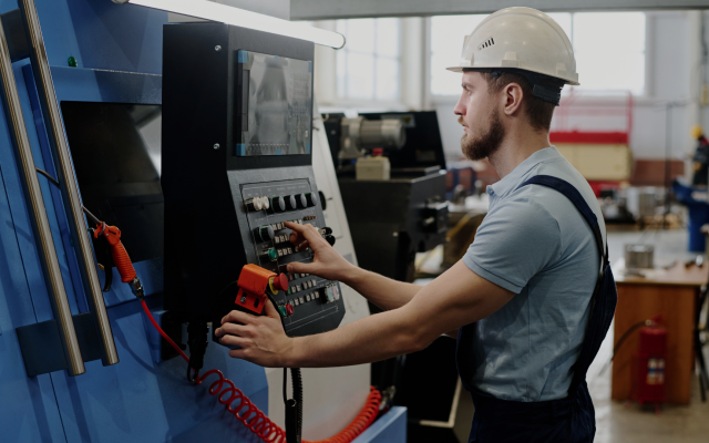 CNC machine operator working at a CNC machine control panel